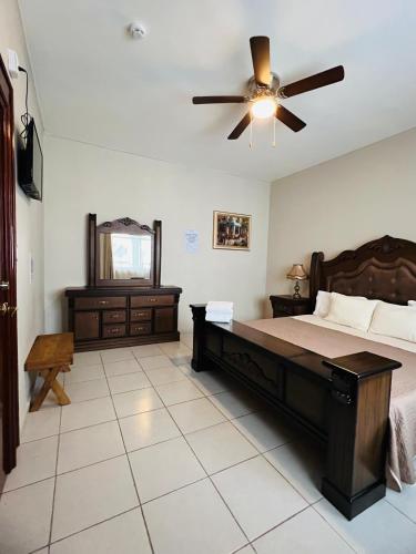 a bedroom with a bed and a ceiling fan at Hostería Casa Marquez in León