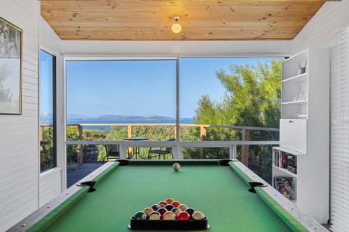 a pool table in a room with a balcony at Ocean Views 20kms from CBD Sleeps 10 in Kingston Beach