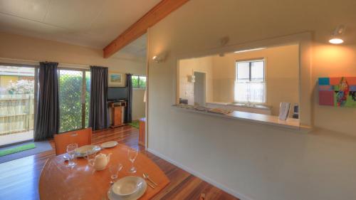 a living room with a table and a large mirror at Village Stays Bungalow and Apartment in Ulmarra