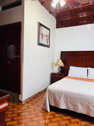 a hotel room with a bed and a television at Hostería Casa Marquez in León