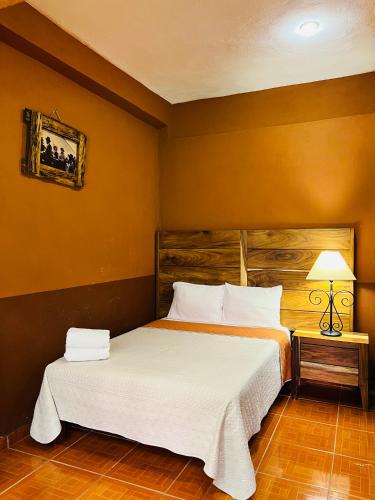 a bedroom with a large bed with white sheets at Hostería Casa Marquez in León