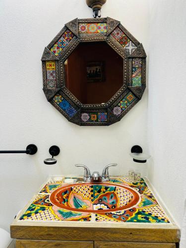 a bathroom with a mosaic sink with a mirror at Hostería Casa Marquez in León