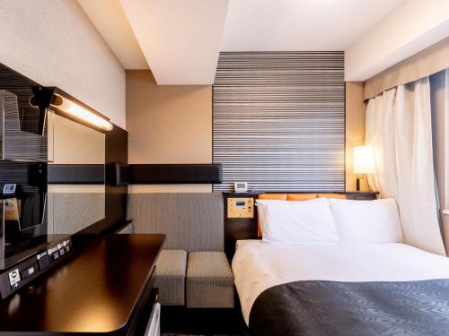 a hotel room with a bed and a desk at APA Hotel Suidobashi Ekimae in Tokyo