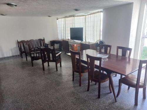 a dining room with tables and chairs and a television at Casa blanca in Maguey Blanco