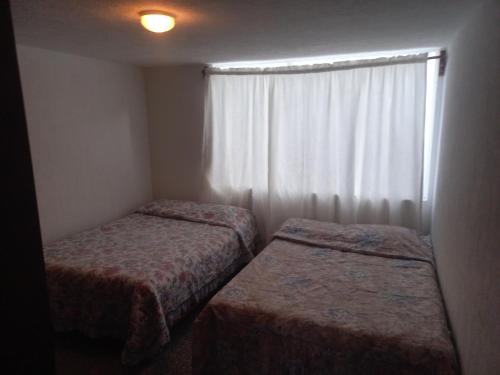 a small room with two beds and a window at Casa blanca in Maguey Blanco