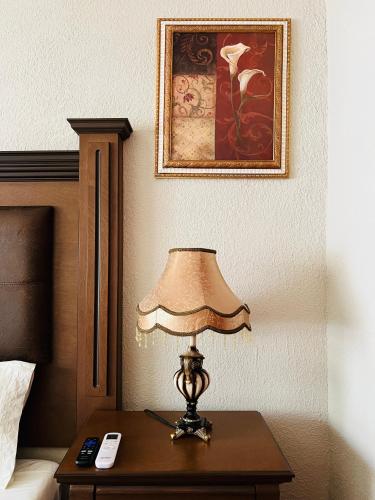 a lamp on a table next to a bed at Hostería Casa Marquez in León