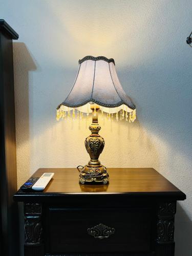 a lamp sitting on a table with a remote control at Hostería Casa Marquez in León