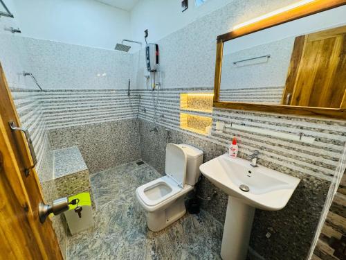 a bathroom with a toilet and a sink at Beach Wave Hotel in Arugam Bay