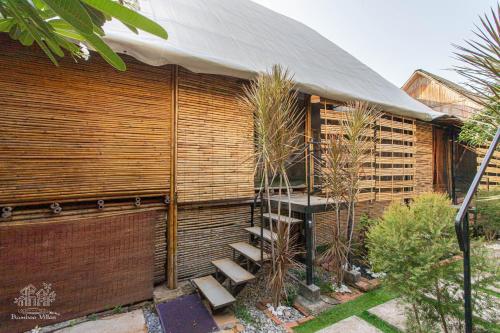 a house with a wooden wall with stairs next to it at Bamboo Villas Huahin #1 in Hua Hin