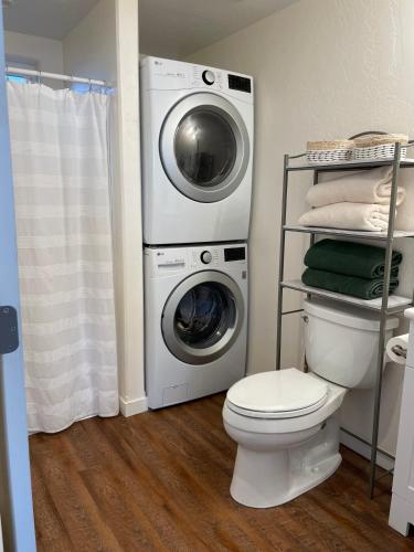 a bathroom with a washing machine and a toilet at Darling Downtown Cottage - summer in CDA! in Coeur d'Alene