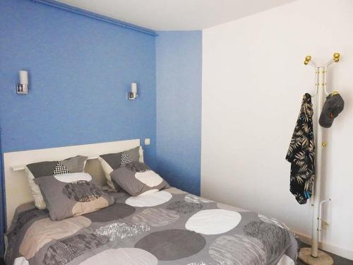 une chambre avec un lit et un mur bleu dans l'établissement Gîte au-dessus de l'Auberge, forêt des Colettes, animaux acceptés - FR-1-489-569, à Louroux-de-Bouble