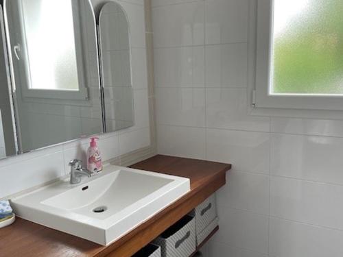 une salle de bain blanche avec un lavabo et un miroir dans l'établissement Maison de Vacances à Noirmoutier - 4 Pers - Animaux Admis - FR-1-823-147, à Noirmoutier-en-l'lle