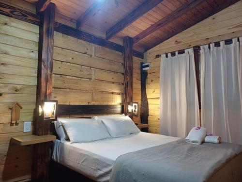 a bedroom with a bed in a wooden room at Cabañas Lignum Tiny House in La Granja