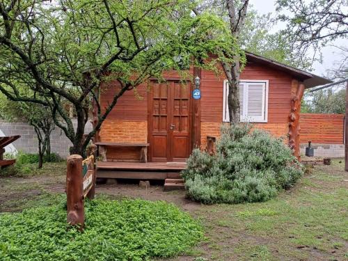 a wooden cabin with a bench in front of it at Cabañas Lignum Tiny House in La Granja