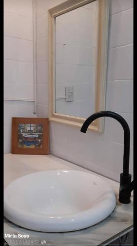 a bathroom sink with a faucet and a mirror at Quinta Ogarupa in Corrientes