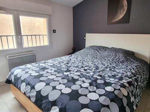 une chambre avec un lit avec une couette noire et blanche dans l'établissement Charmant T2 avec Grande Terrasse à Port-Vendres - FR-1-309-502, à Port-Vendres