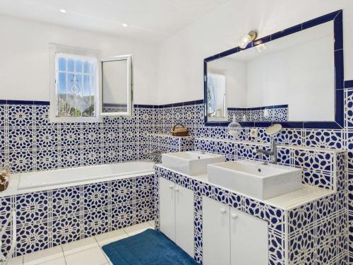 - une salle de bains bleue et blanche avec deux lavabos et un miroir dans l'établissement Maison 4 chambres proche mer, jardin et terrasse - FR-1-423-322, au Grau-dʼAgde