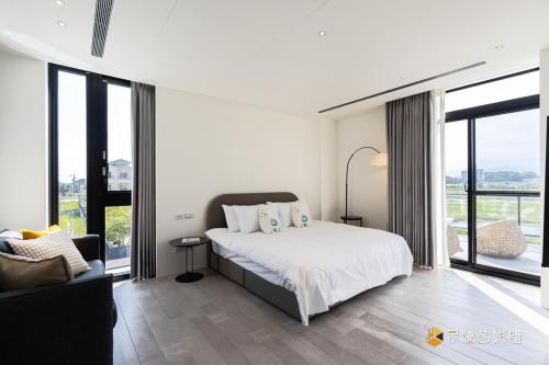 Un dormitorio con una cama y un sofá y ventanas. en 金湯8號, en Yuanshan