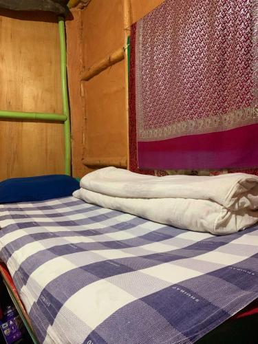 a bed in a room with a checkered blanket at Sisters homestay in Nagarkot