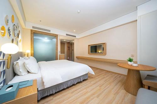 Postel nebo postele na pokoji v ubytování Mediterranean Hotel, Zhangmutou Branch, Dongguan