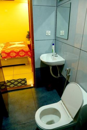a small bathroom with a toilet and a sink at The Aster Apartment in Trivandrum