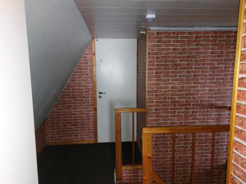 a room with a brick wall and a white door at Livonia Matkamaja in Kilingi-Nõmme