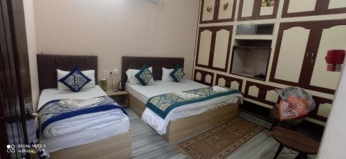 a room with two beds and a mirror at Unnati Residency in Varanasi