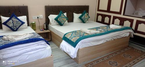 two beds in a hotel room with towels on them at Unnati Residency in Varanasi