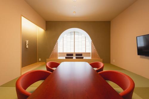 a conference room with a wooden table and chairs at Arima Kirari in Kobe
