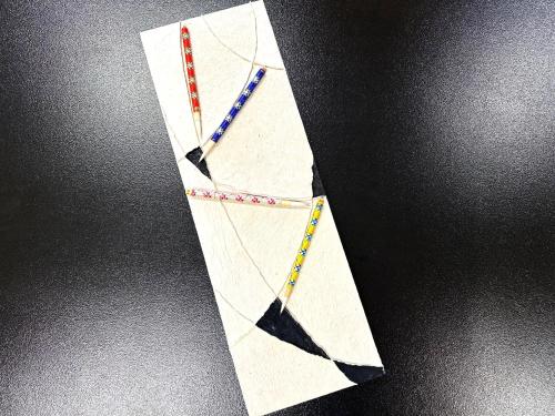a kite with three different colored necklaces on it at Arima Kirari in Kobe