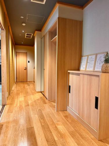 a hallway with wooden doors and wooden floors at Arima Kirari in Kobe