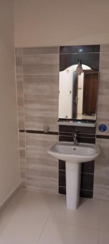a bathroom with a sink and a mirror at شقق البيت الجديد - شقق مخدومه in Yanbu