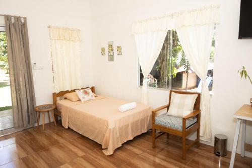 a bedroom with a bed and a chair and a window at Chaikoni Lodge in Pucallpa