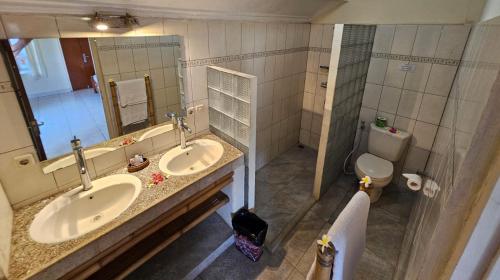 un bagno con due lavandini e un water di Hotel Chonos a Lovina