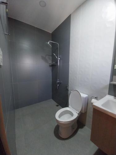 a bathroom with a toilet and a shower and a sink at Sunny Villa DJE in Angeles