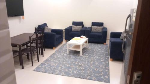 a living room with blue couches and a table at شقق البيت الجديد - شقق مخدومه in Yanbu
