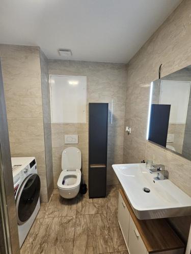 a bathroom with a white toilet and a sink at Moderný 1 izbový apartmán v Ružinove in Bratislava