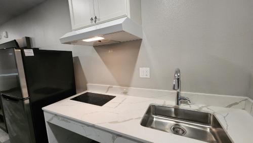 a kitchen with a sink and a black refrigerator at Hotel Park Place in Houston
