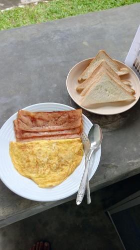 a plate of breakfast food with eggs and toast at The living glamping and homestay in Penebel