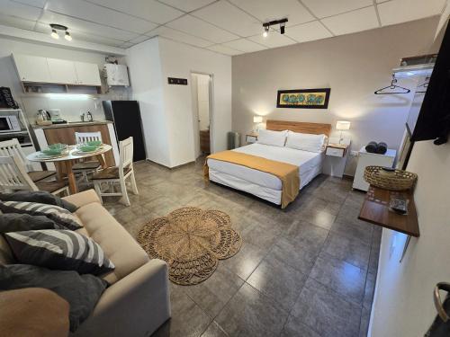 ein Schlafzimmer mit Bett und ein Wohnzimmer in der Unterkunft El Quebracho, Suites y Apartments in Corrientes