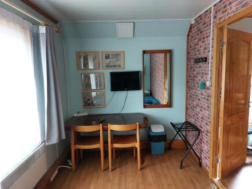 a room with a table and two chairs and a television at Livonia Matkamaja in Kilingi-Nõmme