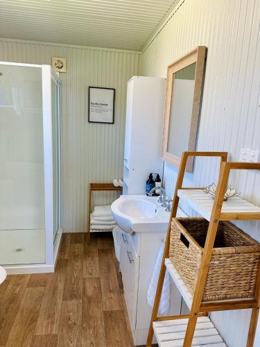 a bathroom with a sink and a mirror at Cabin Bellbird in Bermagui