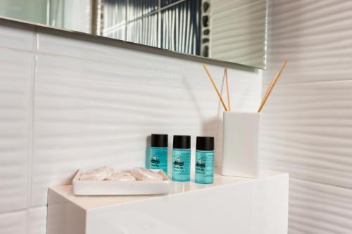 a white shelf with three products on it in a bathroom at Thetis in Alikanas