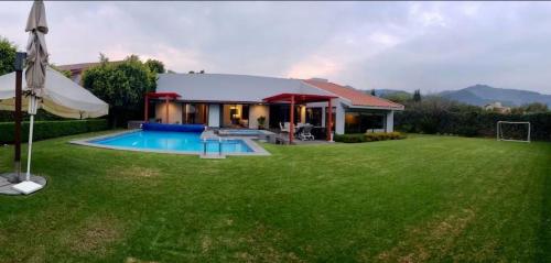 ein Haus mit einem großen Garten mit Pool in der Unterkunft CASA MOSHI in Malinalco