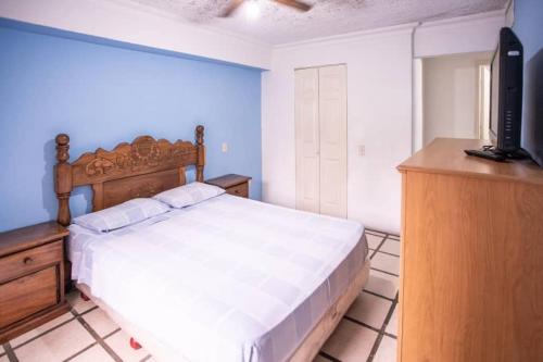 a bedroom with a bed and a dresser and a television at MAR SERENA Vacaciones SC in Porlamar
