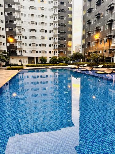 a large blue swimming pool with buildings in the background at The ARC Suites in Manila