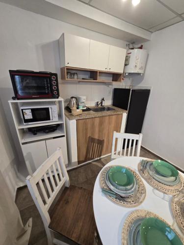 eine Küche mit einem Tisch und 2 Stühlen mit Tellern drauf in der Unterkunft El Quebracho, Suites y Apartments in Corrientes