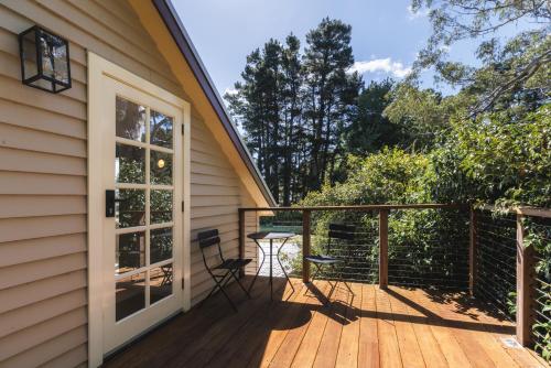 a deck with two chairs and a table on it at Dennarque Estate in Mount Wilson