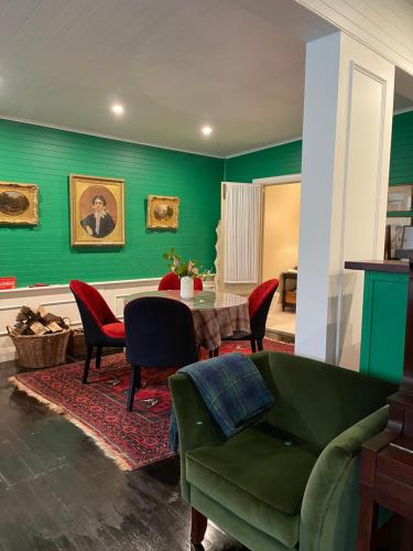 a living room with green walls and a table and chairs at Dennarque Estate in Mount Wilson