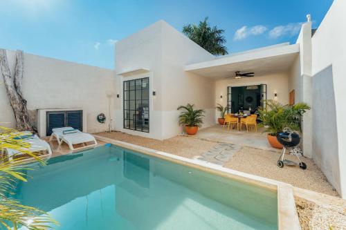 a villa with a swimming pool and a house at Casa Mara 53 Luxury House in downtown Mérida in Mérida